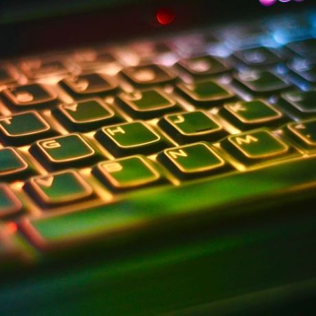 Close-up of keyboard back lit with red, orange and blue colours.